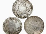 trois pièces d'argent de tailles et de formes différentes sur un fond blanc