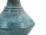 a green vase that is sitting on a white surface