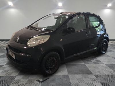 la photo d'une petite voiture noire sur un sol en damier