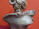 une statue représentant une femme avec une fleur dans les cheveux