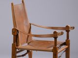 une image représentant une chaise en bois avec une assise en cuir marron
