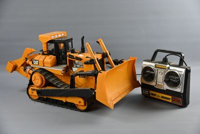 a toy bulldozer next to a radio on a table