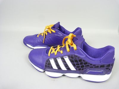 purple and white shoes with yellow laces on them on a white surface
