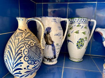 trois vases posés sur un plan de travail carrelé de bleu