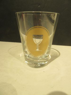 a shot glass sitting on a table with a yellow sticker on it