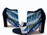 le talon d'une femme portant une paire de chaussures bleues et vertes