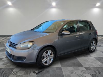 a silver volkswagen golf is parked in a room with a checkered floor
