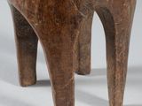a close up of a wooden horse statue on a white surface