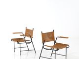 two chairs with leather seats and a metal frame on a white background