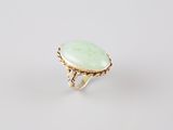 a gold ring with a green jade stone in the center