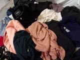 a pile of clothes that is on a bed