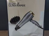 packaging of a hair dryer sitting on a table with a hair dryer in the background