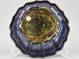 a close up of a purple and green plate on a clear stand
