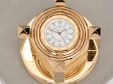 une horloge en or posée sur un plateau en or