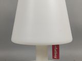 une lampe de table blanche sur laquelle est apposée une étiquette rouge