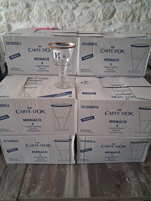 several boxes of carton dor on a wooden table with a glass on top