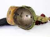 a silver and gold helmet with a long black hair