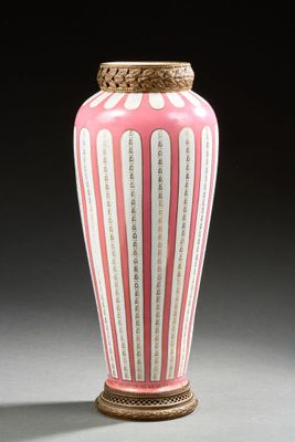 un vase rose et blanc posé sur une table