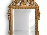 an ornate gold mirror with a bird on top of it