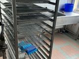 a large metal rack in a kitchen with blue bins