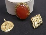 trois bijoux, dont une bague, un pendentif et une pièce de monnaie