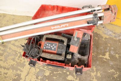 a red box with two tools in it on the floor