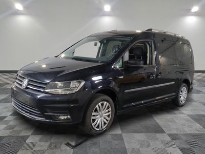 La camionnette noire est garée sur un sol en dalles à damier.