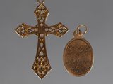 two gold crosses and a penny on a gray background