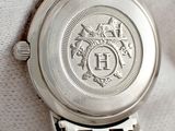 a close up of a silver watch on a white cloth