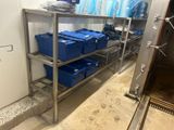 a metal shelf with blue containers on it in a room