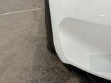 a close up of a white car parked in a parking lot