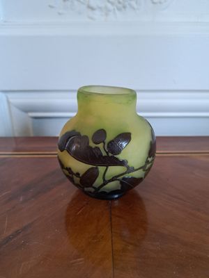 un petit vase posé sur une table au plateau en bois