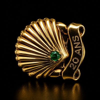 une image d'une bague en or avec une pierre verte au centre
