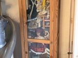 a tall wooden cabinet with a glass door in a kitchen