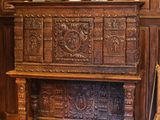 une armoire en bois au milieu d'une pièce, sur laquelle est posé un vase