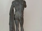 statue of a man holding a towel on a marble base
