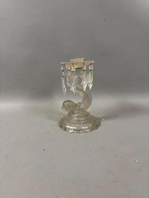 un petit bougeoir en verre orné d'un oiseau