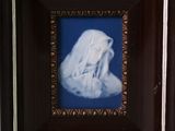 painting of a woman in a white robe in a dark wood frame