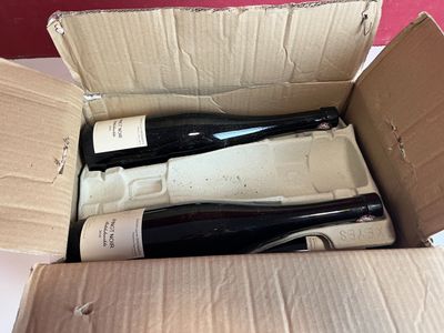 deux bouteilles de vin dans une boîte en carton posée sur une table