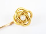 une photo d'une broche en forme de fleur, en or et perles