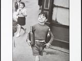 photographie en noir et blanc d'un jeune garçon marchant dans la rue