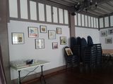 tables and chairs in a room with pictures on the wall