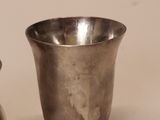 pair of silverplated cups on a white surface