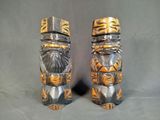 deux totems en bois et en métal sur fond gris
