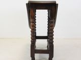 an old wooden stool with turned legs and a wooden seat