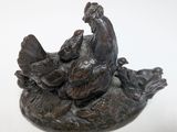 a figurine of a chicken and a bird on a rock