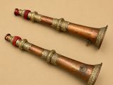 paire de clochettes anciennes en laiton ornées de perles rouges sur fond beige