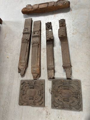 Plusieurs pièces de bois sculpté sont posées sur une table, à côté d'un couteau.