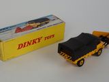 yellow and black toy truck next to a yellow box on a white surface