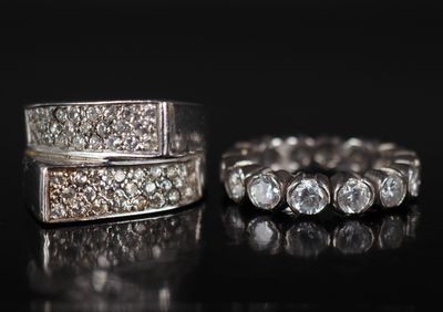 une paire de bagues en diamant posées sur une surface noire, avec un reflet